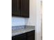 Close up on granite counters, dark cabinets, and a walk in pantry at 2705 Grandbury Grove Rd, Lakeland, FL 33811