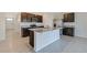Modern kitchen with granite countertops, stainless steel appliances, a center island, and tile flooring at 2705 Grandbury Grove Rd, Lakeland, FL 33811