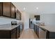 Modern kitchen featuring granite countertops, stainless steel appliances, dark cabinetry, and tile flooring at 2705 Grandbury Grove Rd, Lakeland, FL 33811