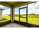 The screened patio overlooks a lush green lawn with distant view of the lake and trees at 2705 Grandbury Grove Rd, Lakeland, FL 33811