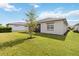 Lush green backyard with manicured lawn and view of the home's exterior and screened lanai at 2748 Greenlands St, St Cloud, FL 34772