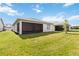 Well-maintained backyard featuring a grassy lawn and the exterior of the home with a screened-in patio at 2748 Greenlands St, St Cloud, FL 34772