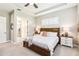 Bedroom featuring a tray ceiling, ceiling fan, windows with shutters, and an ensuite bathroom at 2748 Greenlands St, St Cloud, FL 34772