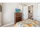 Cozy bedroom featuring patterned bedding, a dresser with a TV, and an open door leading to the hallway at 2748 Greenlands St, St Cloud, FL 34772