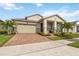 Inviting home featuring a two-car garage, manicured landscaping, and a covered front porch at 2748 Greenlands St, St Cloud, FL 34772