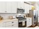 Close up of kitchen featuring stainless steel appliances, gas range, and white cabinets at 2748 Greenlands St, St Cloud, FL 34772