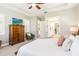 Spacious main bedroom with ceiling fan, ensuite bath, dresser, and sitting chair at 2748 Greenlands St, St Cloud, FL 34772