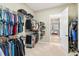 Bright walk-in closet featuring ample hanging space, shelving, and neutral carpeting, offering excellent storage solutions at 2748 Greenlands St, St Cloud, FL 34772