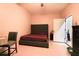 A bedroom features a bed, chair, and access to a door, complemented by neutral walls and tiled floors at 2820 Avian Loop, Kissimmee, FL 34741