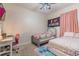 Cozy bedroom featuring two twin beds with colorful floral bedding, a desk and a large pink curtain at 2820 Avian Loop, Kissimmee, FL 34741