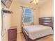 Bedroom featuring a ceiling fan, a window with blinds and patterned curtains, and a bed with a white comforter at 2820 Avian Loop, Kissimmee, FL 34741