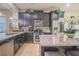 Modern kitchen with stainless appliances, granite counters, dark cabinets, and tile backsplash at 2820 Avian Loop, Kissimmee, FL 34741