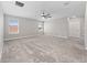 Bright, carpeted bedroom with a ceiling fan, two windows, and a neutral color palette at 3038 Camden Way, Davenport, FL 33837