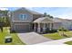 Well-maintained two-story home with a front lawn, paver driveway, and an attached two-car garage at 3038 Camden Way, Davenport, FL 33837