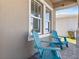 Inviting front porch with blue Adirondack chairs and brick pavers; a relaxing outdoor space at 3038 Camden Way, Davenport, FL 33837