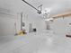 Large garage with ample lighting, painted floor, built-in shelf storage, and plenty of open space at 3038 Camden Way, Davenport, FL 33837