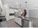 Well-lit kitchen featuring stainless appliances, white cabinets, a center island with a double sink, and tile floors at 3038 Camden Way, Davenport, FL 33837