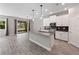 Bright open kitchen and dining area featuring an island with bar seating and sliding glass doors to the patio at 3038 Camden Way, Davenport, FL 33837