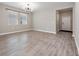 Bright living room with modern light fixture, wood tile flooring, and two windows at 3038 Camden Way, Davenport, FL 33837