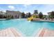 Community pool with zero entry, mushroom fountain, and water slide surrounded by lush landscaping at 3038 Camden Way, Davenport, FL 33837
