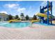 Community pool with water slides, mushroom fountain and plentiful seating under sunny blue sky at 3038 Camden Way, Davenport, FL 33837