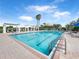 Community lap pool with pergola covered seating, lush landscaping and beautiful blue sky at 3038 Camden Way, Davenport, FL 33837