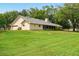 Expansive backyard with lush green grass and a screened-in porch, ideal for outdoor living at 3075 Simpson Rd, Kissimmee, FL 34744