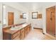 Bathroom featuring double sinks, wooden cabinets, and a large mirror, with a tiled shower at 3075 Simpson Rd, Kissimmee, FL 34744