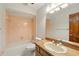 Bathroom with tub and shower combo, retro pink tile, and wood vanity with an oval sink at 3075 Simpson Rd, Kissimmee, FL 34744