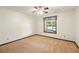 Bedroom featuring neutral carpet, light-colored walls, ceiling fan, and a window with curtains at 3075 Simpson Rd, Kissimmee, FL 34744