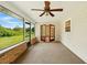 Relaxing sunroom with brick accents, tile flooring, ceiling fan, and beautiful view of the backyard at 3075 Simpson Rd, Kissimmee, FL 34744