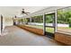 Enclosed sunroom with tile flooring, brick accents, ceiling fans, and a view of a wooded backyard at 3075 Simpson Rd, Kissimmee, FL 34744