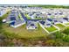 Expansive aerial view of a residential community featuring modern homes, lush greenery and water views at 3161 Royal Tern Dr, Winter Haven, FL 33881