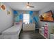 Bright bedroom with a single bed, geometric accent wall, ceiling fan, and a wall mounted television at 3161 Royal Tern Dr, Winter Haven, FL 33881