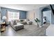 Comfortable living room featuring a large gray sectional sofa, sleek gray flooring, and ample natural light from a window at 3161 Royal Tern Dr, Winter Haven, FL 33881