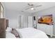 Spacious bedroom with neutral walls, a ceiling fan, dresser with tv and access to the bathroom and walk-in closet at 3161 Royal Tern Dr, Winter Haven, FL 33881