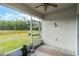 Enclosed patio overlooking the fenced in backyard and beautiful wooded scenery, with a ceiling fan at 3161 Royal Tern Dr, Winter Haven, FL 33881