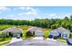 Street view of three modern homes with lush landscaping and well-manicured lawns, showing curb appeal at 3161 Royal Tern Dr, Winter Haven, FL 33881
