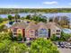 Aerial view of colorful townhomes next to a serene lake and lush landscaping at 3344 Corona Village Way # 308, Orlando, FL 32835