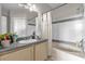 Well-lit bathroom featuring a single vanity, bathtub with shower, and coordinated neutral color scheme at 3344 Corona Village Way # 308, Orlando, FL 32835