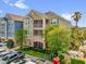 Multi-story condominium featuring private screened balconies and a well-maintained lawn at 3344 Corona Village Way # 308, Orlando, FL 32835