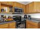Close up of kitchen with stainless steel microwave and oven, wooden cabinets, and gray countertops at 3344 Corona Village Way # 308, Orlando, FL 32835