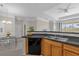 View of the modern kitchen with stainless steel sink, black dishwasher, and breakfast bar overlooking the dining area at 3344 Corona Village Way # 308, Orlando, FL 32835