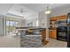 Open concept kitchen features modern appliances, sleek countertops, and a breakfast bar with decorative tile at 3344 Corona Village Way # 308, Orlando, FL 32835