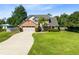 Beautiful home featuring mature trees, a lush green lawn, and a long driveway leading to a two-car garage at 3820 Forest Cir, St Cloud, FL 34772