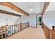 Upstairs hallway with wood railing and exposed wood beams, leading to another room at 3820 Forest Cir, St Cloud, FL 34772