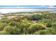 Aerial view showcasing the home's location amidst lush greenery and near a serene lake. Property line is marked in red at 420 Ketch Rd, St Cloud, FL 34771