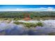 Stunning aerial view of large wooded lot, partially cleared, marked with red outline, and surrounded by lake and wetlands at 420 Ketch Rd, St Cloud, FL 34771