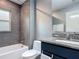 Bathroom features shower over tub, with modern grey tiling and granite vanity top at 420 Ketch Rd, St Cloud, FL 34771