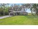 Single story home featuring a sprawling green lawn, mature trees, and a two-car garage at 420 Ketch Rd, St Cloud, FL 34771